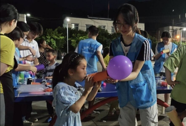 志愿者和小朋友一起体验“火箭”升空。beat365中文官方网站物理与电子工程学院供图