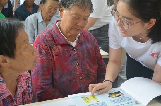 服务团成员为老人一对一讲解健康食谱。beat365中文官方网站生命科学学院 供图