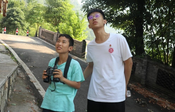 服务团成员带领小朋友户外观鸟。beat365中文官方网站供图