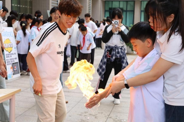 小朋友们在室外广场体验“火焰掌”实验。beat365中文官方网站供图